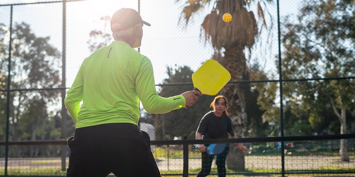 Two adults playing pickleball