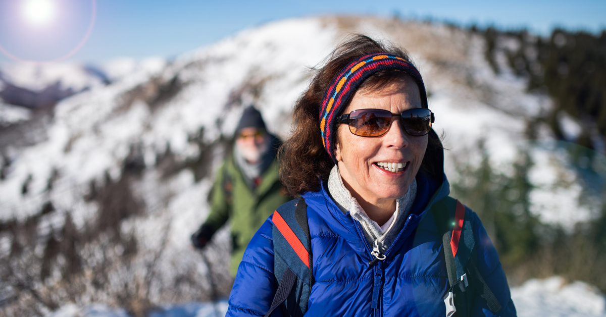 Mature individual hiking a snowcapped mountain