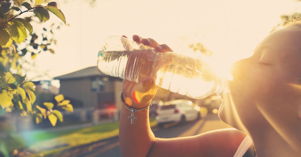 Woman drinking water in the sunlight